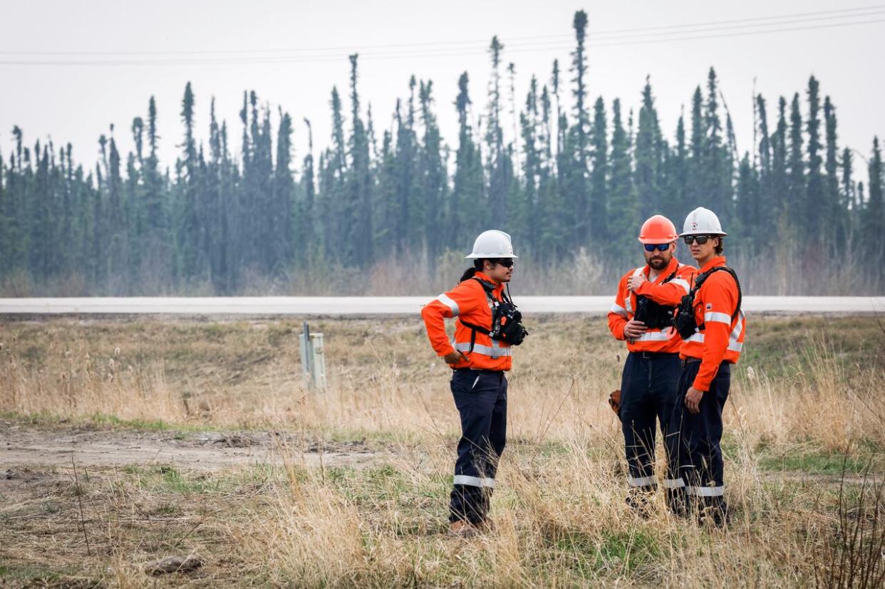 Wildfire specialists with Fire & Flood Emergency Service Ltd., pictured along Highway 881 near Gregoire Lake Estates southeast of Fort McMurray on Wednesday.  (Jeff McIntosh/The Canadian Press - image credit)