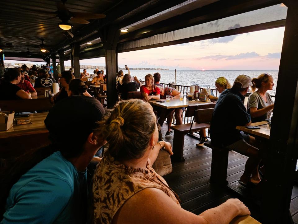 Kristin Tatangelo, left, and Rebecca Tatangelo watch the sunset while at Harpoon Harry's in Fishermen's Village in Punta Gorda.