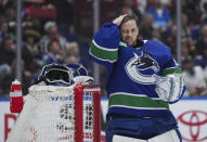 Vancouver Canucks goalie Casey DeSmith fixes his hair before putting his mask back on during a stoppage while playing the Washington Capitals during the second period of an NHL hockey game in Vancouver, British Columbia, on Saturday, March 16, 2024. (Darryl Dyck/The Canadian Press via AP)