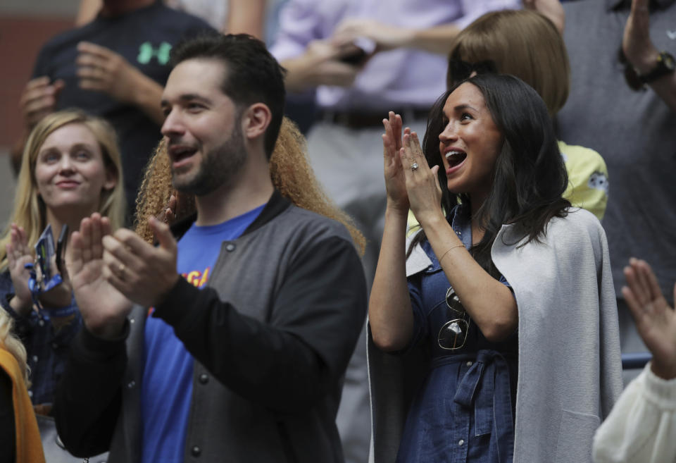 Meghan, Duchess of Sussex, right, and Alexis Ohanian, left, applaud as players are introduced before the start of the women's singles final of the U.S. Open tennis championships between Serena Williams, of the United States, and Bianca Andreescu, of Canada, Saturday, Sept. 7, 2019, in New York. (AP Photo/Charles Krupa)