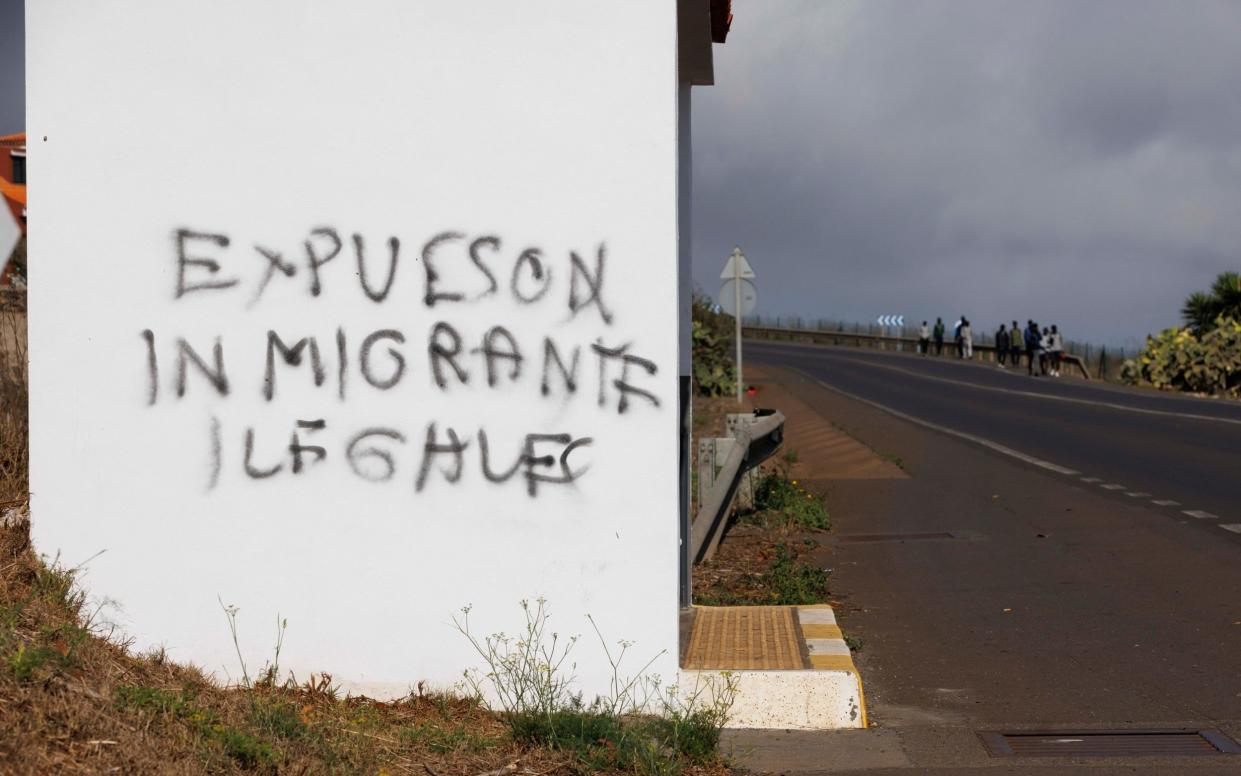 Graffiti on a bus shelter close to the Centro de inmigrantes Las RaÃ­ces, a migrant camp alongside Tenerifeâ€™s North airport