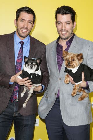 <p>Chelsea Lauren/WireImage</p> Drew and Jonathan Scott with dogs Gracie and Stewie.