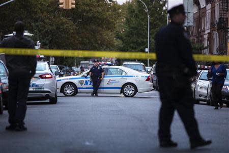 New York Police Department officers stand in the street outside of where Cathleen Alexis, mother of Aaron Alexis lives in New York, September 16, 2013. REUTERS/Lucas Jackson