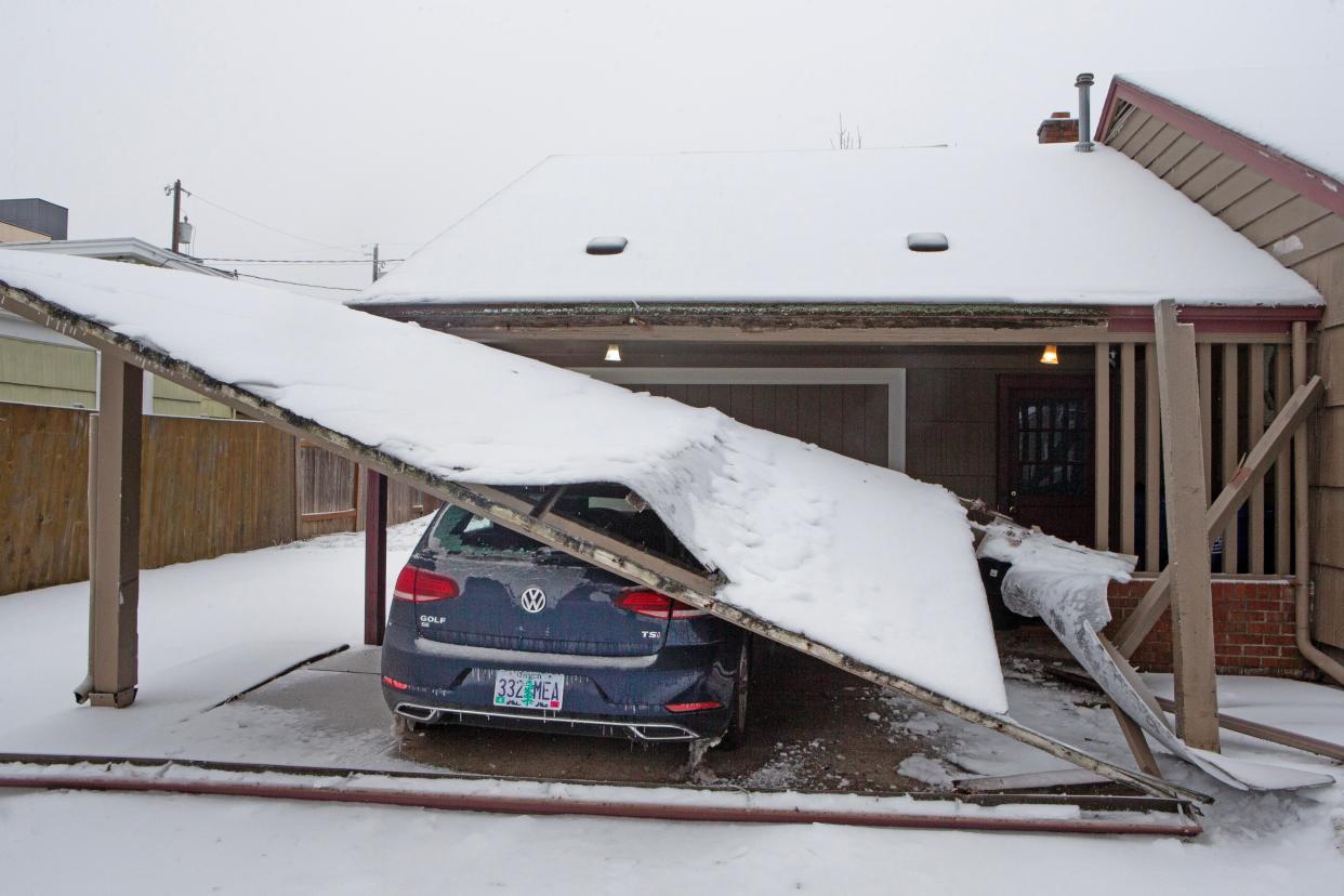 A carport brought down by heavy ice and snow lays on a car in Eugene Sunday, Jan. 14, 2024 after more snow and ice fell on the Willamette Valley.