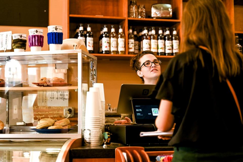 The Hob Nob coffee shop owner Trisha Kosloski, left, helps customer Alyssa Hengesbach on Monday, Oct. 2, 2023, in downtown Lansing.