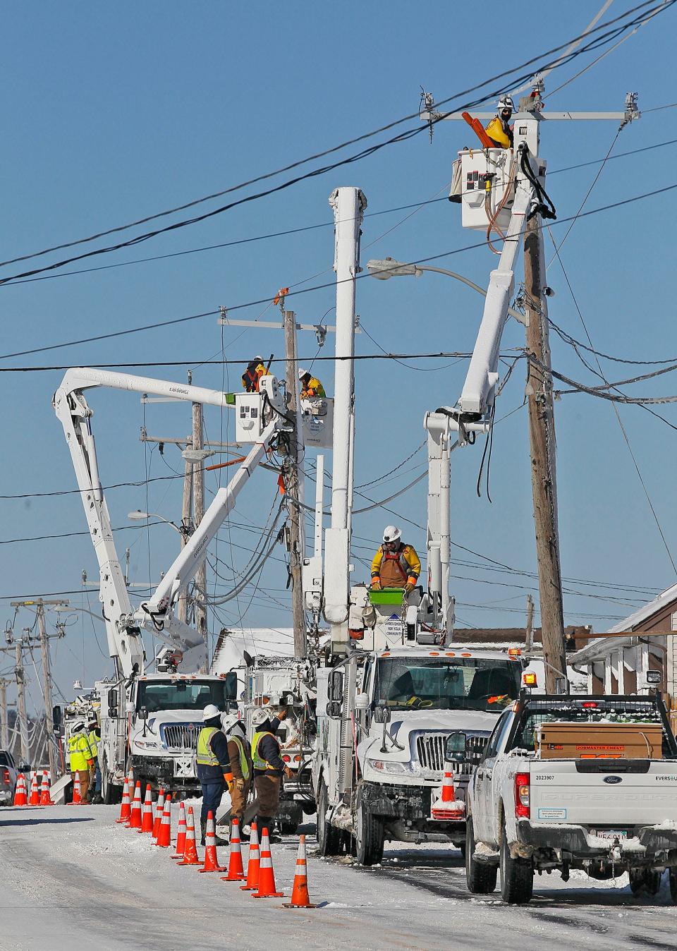 Utility crews work on twisted and downed wires in the Ocean Bluff neighborhood of Marshfield on Sunday, Jan. 30, 2022.