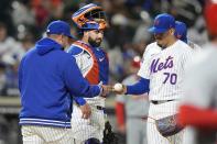 New York Mets catcher Tomás Nido watches as pitcher José Buttó, right, hands the ball to manager Carlos Mendoza during the sixth inning of the team's baseball game against the St. Louis Cardinals, Friday, April 26, 2024, in New York. (AP Photo/Frank Franklin II)