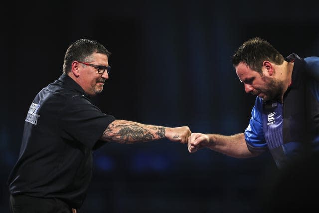Gary Anderson (left) bumps fists with Adrian Lewis 
