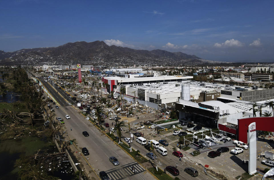 The sides of a main road is lined with debris and affected commercial buildings two days after the passage of Hurricane Otis hit as a Category 5 storm in Acapulco, Mexico Friday, Oct. 27, 2023. (AP Photo/Marco Ugarte)