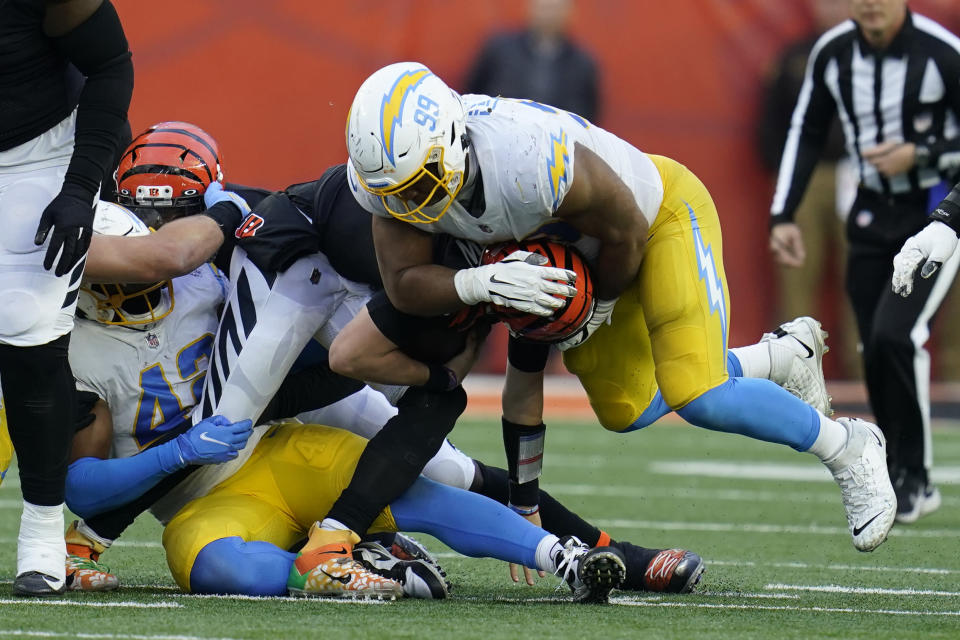 Cincinnati Bengals quarterback Joe Burrow (9) is sacked by Los Angeles Chargers' Jerry Tillery (99) during the second half of an NFL football game, Sunday, Dec. 5, 2021, in Cincinnati. (AP Photo/Michael Conroy)