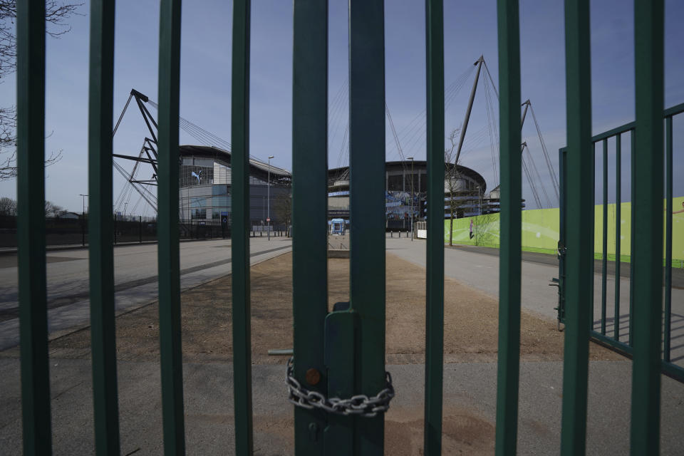 FILE - In this file photo dated Thursday, April 9, 2020, gates stand locked outside the closed English Premier League soccer Manchester City Etihad Stadium, in Manchester, northern England. Guidance for sports bodies was published by the government on Saturday May 30, 2020, as COVID-19 lockdown restrictions are being eased further, allowing Sports events to resume in England from upcoming Monday, without any spectators and providing they comply with the government's coronavirus protocols. (AP Photo/Jon Super, FILE)