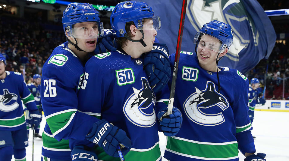 VANCOUVER, BC - MARCH 10: Antoine Roussel #26, Brock Boeser #6, and Troy Stecher #51 of the Vancouver Canucks celebrate after winning their NHL game against the New York Islanders at Rogers Arena March 10, 2020 in Vancouver, British Columbia, Canada. Vancouver won 5-4. (Photo by Jeff Vinnick/NHLI via Getty Images)