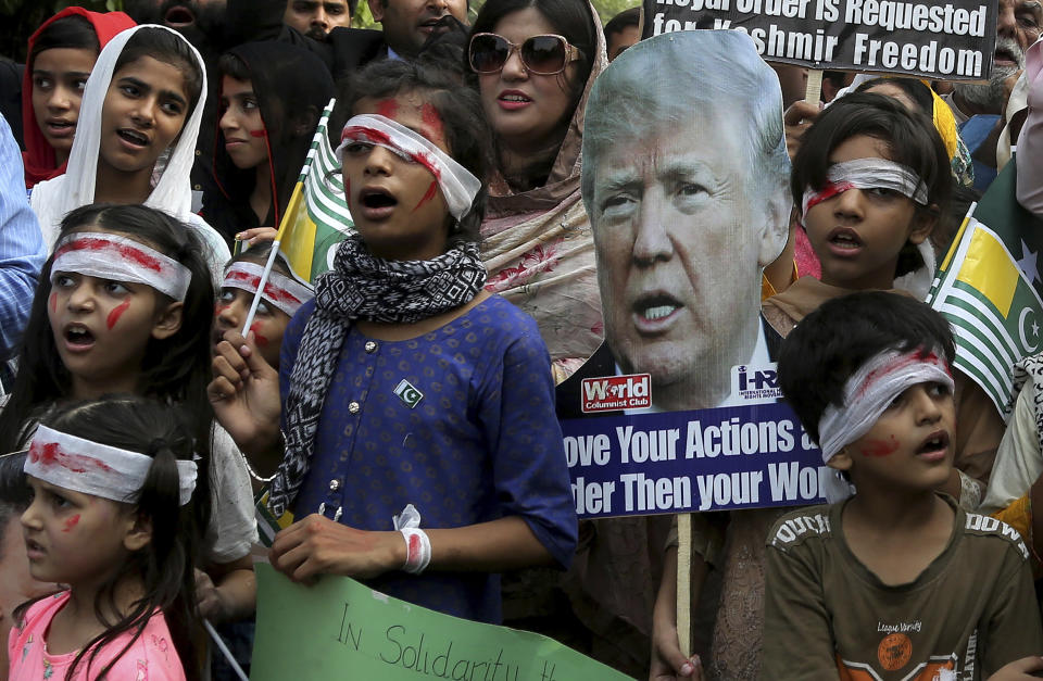 Pakistan children dress up like injured Kashmiri children and hold a portrait of U.S. President Donald Trump during a demonstration organized by International Human Right Movement to express solidarity with Indian Kashmiris, in Lahore, Pakistan, Sunday, Sept. 22, 2019. Tensions between Pakistan and India, two nuclear-armed countries, has increased since Aug. 5, when India downgraded the autonomy of its side of Kashmir and imposed tighter controls on the area. (AP Photo/K.M. Chaudary)