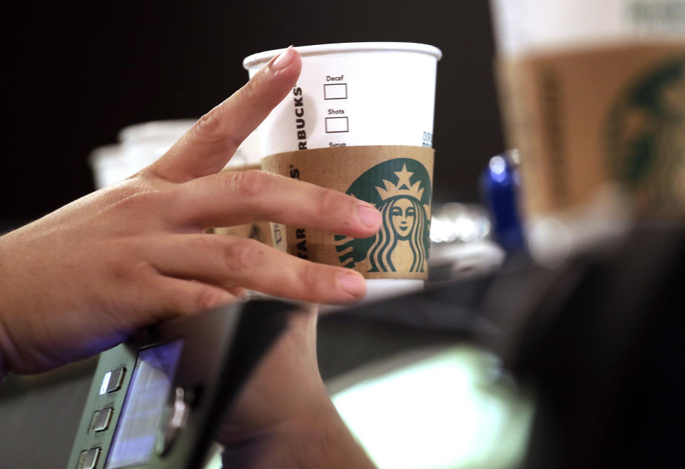 A barista reaches for an empty cup at Starbucks in the Pike Place Market in Seattle. (Elaine Thompson / AP file)