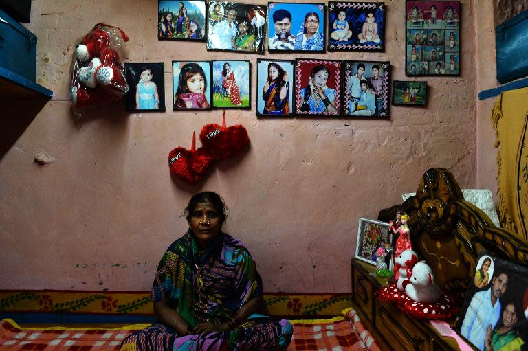 Draupadi, a former leprosy sufferer, poses with pictures of her family in a leprosy colony in New Delhi