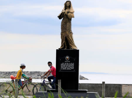 Bikers drive past a memorial statue that commemorates the Filipino "comfort women" who worked in Japanese military brothels during World War II, erected along a main street of Roxas Boulevard, Metro Manila, Philippines January 12, 2018. A message reads "This monument is in honor of Filipino women who were victims of abuse during the Japanese occupation of the Philippines (1942-1945). A long time has passed before they testified and revealed what they went through". REUTERS/Romeo Ranoco