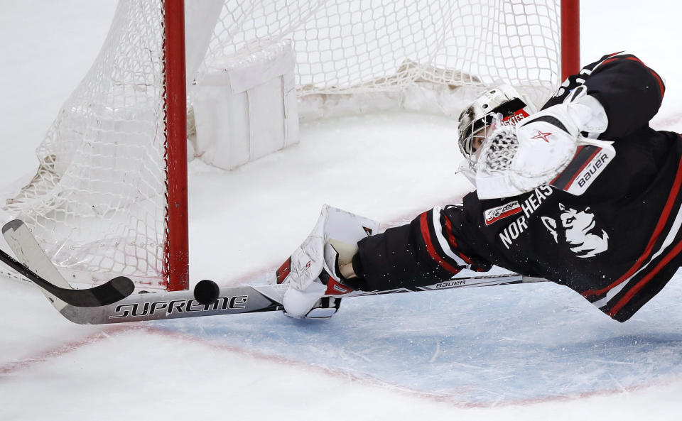 Northeastern goaltender Cayden Primeau dives as he makes a stick save on a shot by Boston College forward Aapeli Räsänen during the third period of the NCAA hockey Beanpot tournament championship game in Boston, Monday, Feb. 11, 2019. (AP Photo/Charles Krupa)
