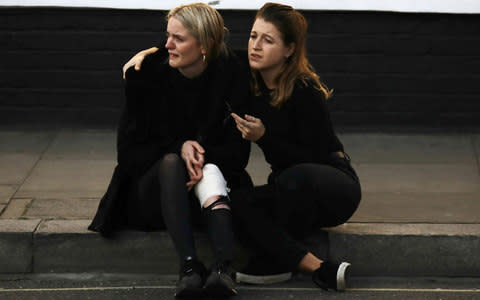 An injured woman outside Parsons Green station - Credit: KEVIN COOMBS/Reuters