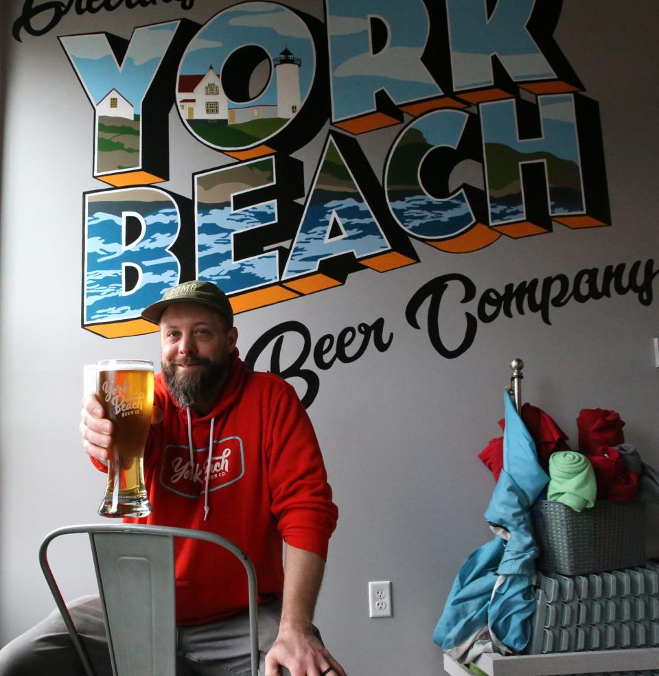 Dave Rowland of York Beach Beer Co. toasts with an amber colored beer they make at their brewery.