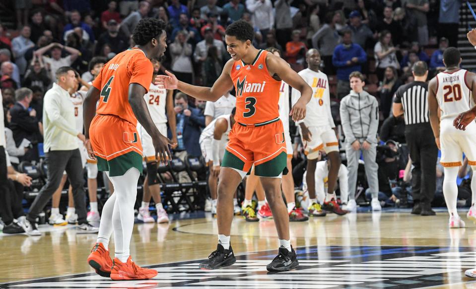 University of Miami guard Beesley Joseph (4) and guard Charlie Moore (3) celebrate after helping beat University of Southern California 68-66 at the NCAA Div. 1 Men's Basketball Tournament preliminary round game at Bon Secours Wellness Arena in Greenville, S.C. Friday, March 18, 2022.