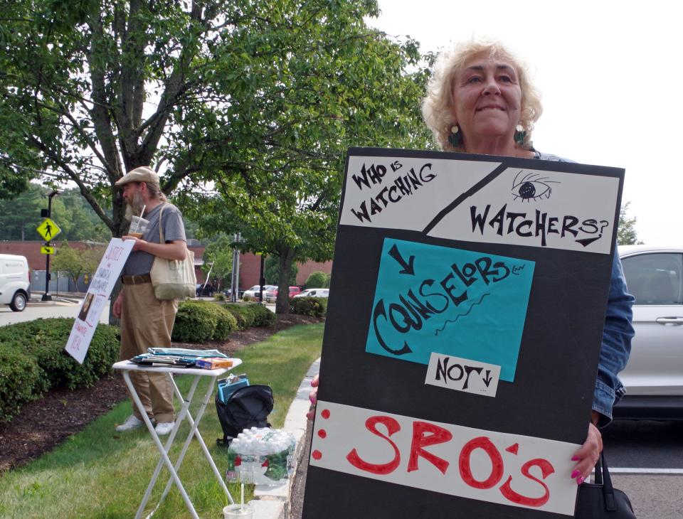 Laura Saylor of Mansfield holds her sign that supports more counselors in school to help troubled kids at a protest at the Norfolk district attorney's office on Monday Aug. 21, 2023, calling for a deeper investigation into the death of Sandra Birchmore. To the left is Owen Broadhurst, who made the trip from his home in Holyoke to show his support.