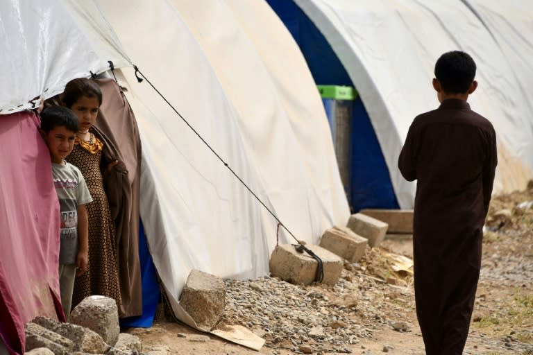 Children stand by tents in April 2024 at the Al-Jadaa camp south of Mosul which houses Iraqi families who have been repatriated from Syria's Al-Hol camp (Zaid AL-OBEIDI)