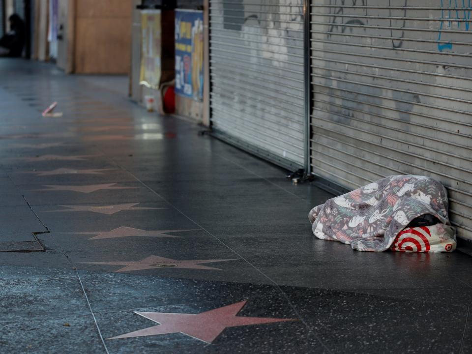 A homeless person sleeps next to the stars placed along the Hollywood Blvd sidewalk in Los Angeles, California, U.S., February 6, 2020. REUTERS:Mike Blake.JPG