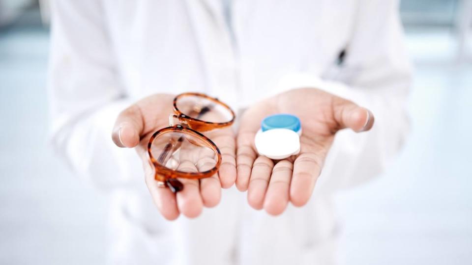 Eye care, choice with glasses or contact lens in hands