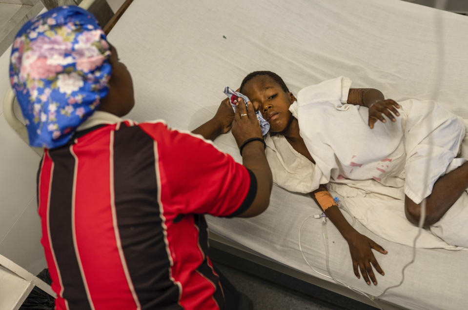 Denize Flerino limpia el sudor de la frente de su hijo, que padece fiebres altas, en una sala de emergencias de Médicos Sin Fronteras en el vecindario de Cite Soleil, en Puerto Príncipe, Haití, el 19 de abril de 2024. (AP Foto/Ramón Espinosa)