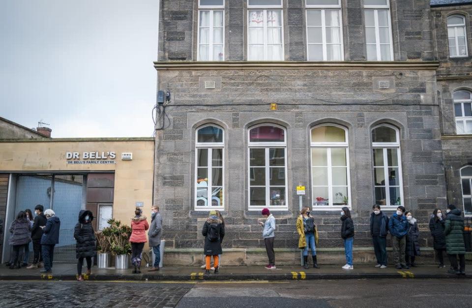 People queue along Junction Place, Edinburgh, for the vaccination centre at the NHS Scotland Leith Community Treatment Centre, as the coronavirus booster vaccination programme is ramped up (Jane Barlow/PA) (PA Wire)