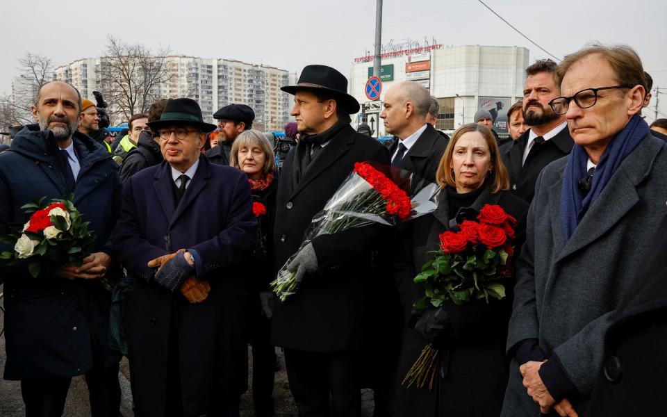 Foreign diplomats, including French Ambassador to Russia Pierre Levy and US Ambassador to Russia Lynne Tracy, wait near the Soothe My Sorrows church