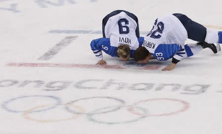 Ice Hockey - Pyeongchang 2018 Winter Olympics - Women's Bronze Medal Match - Finland v Olympic Athletes from Russia - Kwandong Hockey Centre, Gangneung, South Korea - February 21, 2018 - Venla Hovi and Michelle Karvinen of Finland kiss the ice after the match. REUTERS/Kim Kyung-Hoon