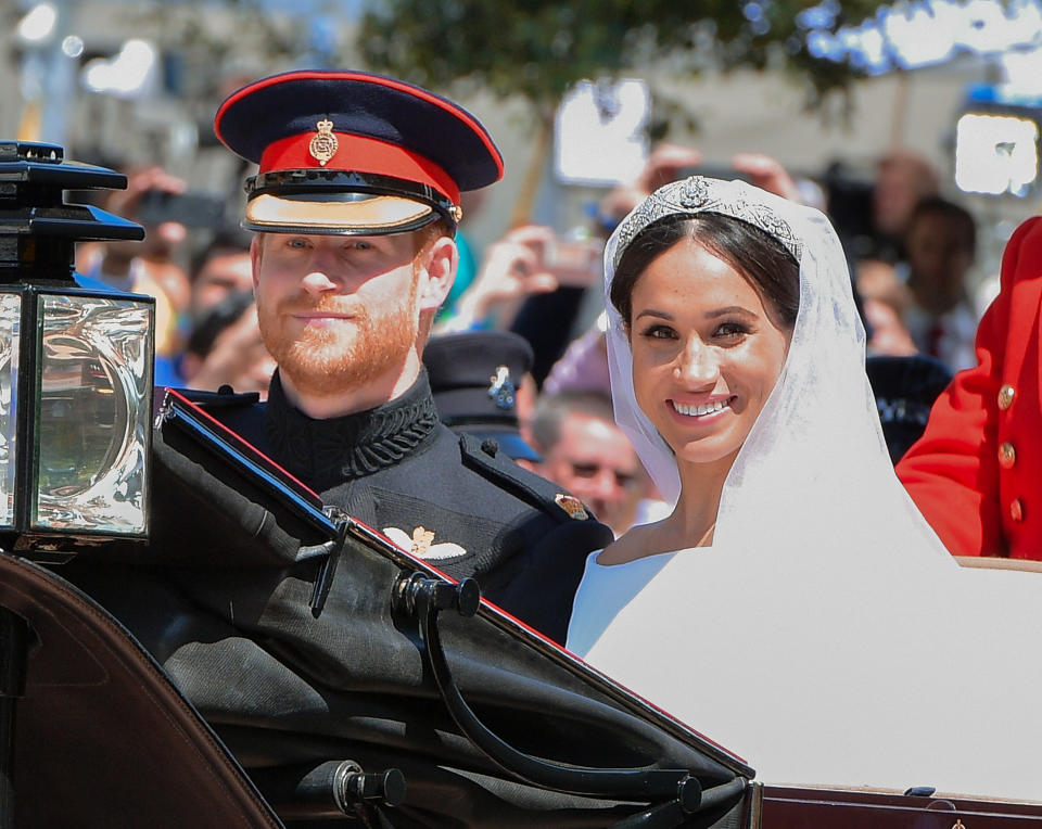 WINDSOR, ENGLAND - MAY 19:  (L-R) Prince Harry, Duke of Sussex and Meghan, Duchess of Sussex leave Windsor Castle in the Ascot Landau carriage during a procession after getting married at St Georges Chapel on May 19, 2018 in Windsor, England. Prince Henry Charles Albert David of Wales marries Ms. Meghan Markle in a service at St George's Chapel inside the grounds of Windsor Castle. Among the guests were 2200 members of the public, the royal family and Ms. Markle's mother, Doria Ragland.  (Photo by George Pimentel/WireImage)