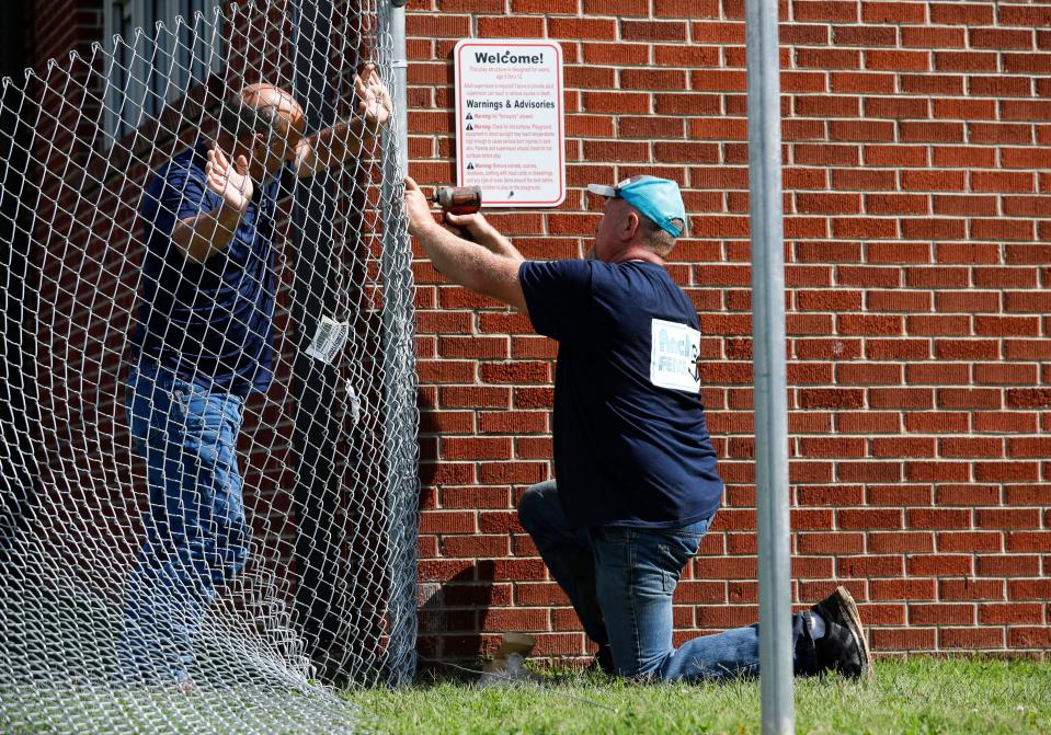 Anchor Fence employees Jason Overholser (right) and John Ott install a fence in the playground area at Bissett Elementary School on Tuesday, Aug. 15, 2023 as part of security upgrades funded by the 2023 bond issue.