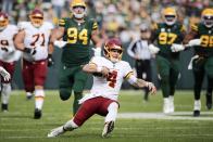 Washington Football Team's Taylor Heinicke runs for a first down during the first half of an NFL football game against the Green Bay Packers Sunday, Oct. 24, 2021, in Green Bay, Wis. (AP Photo/Aaron Gash)