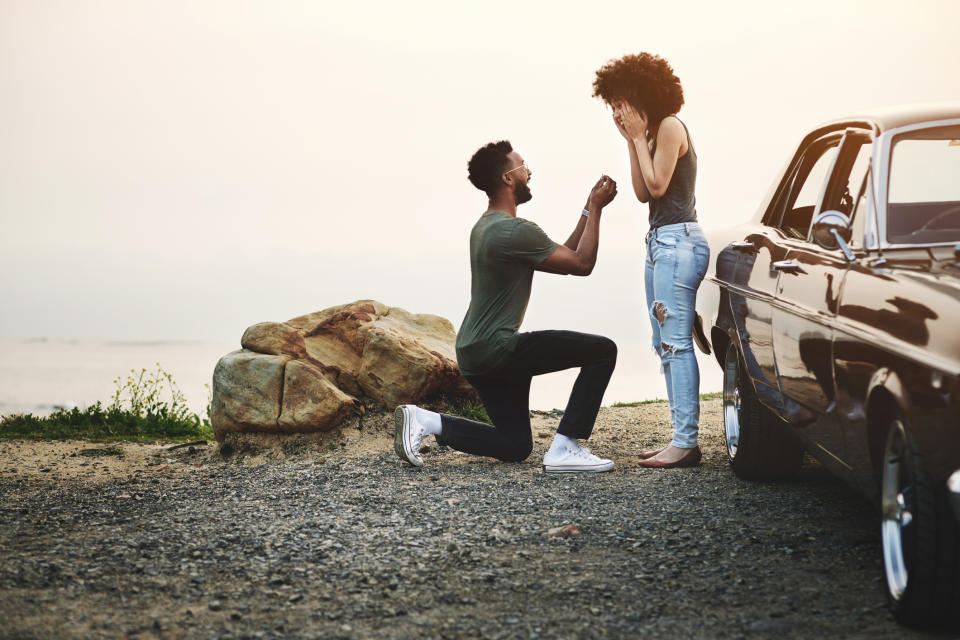 Stock picture of a couple on a beach getting engaged. (Getty Images)