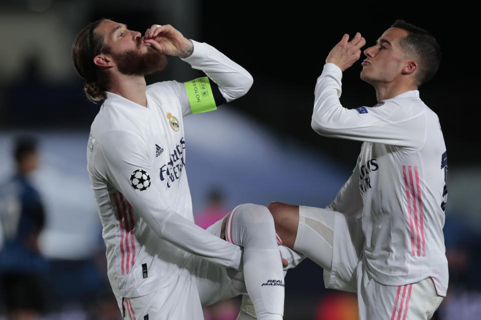 Sergio Ramos (izquierda) y Lucas Vázquez celebran el segundo gol del Real Madrid en el partido contra Atalanta por los octavos de final de la Liga de Campeones, el martes 16 de diciembre de 2021, en Madrid. (AP Foto/Bernat Armangue)