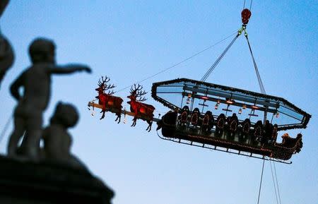 Guests enjoy dinner at the table "Santa in the sky", lifted by a crane and decorated to match the appearance of a "Santa Sleigh" as part as the Christmas festivities, in Brussels, Belgium, November 25, 2016. Picture taken November 25, 2016. REUTERS/Yves Herman