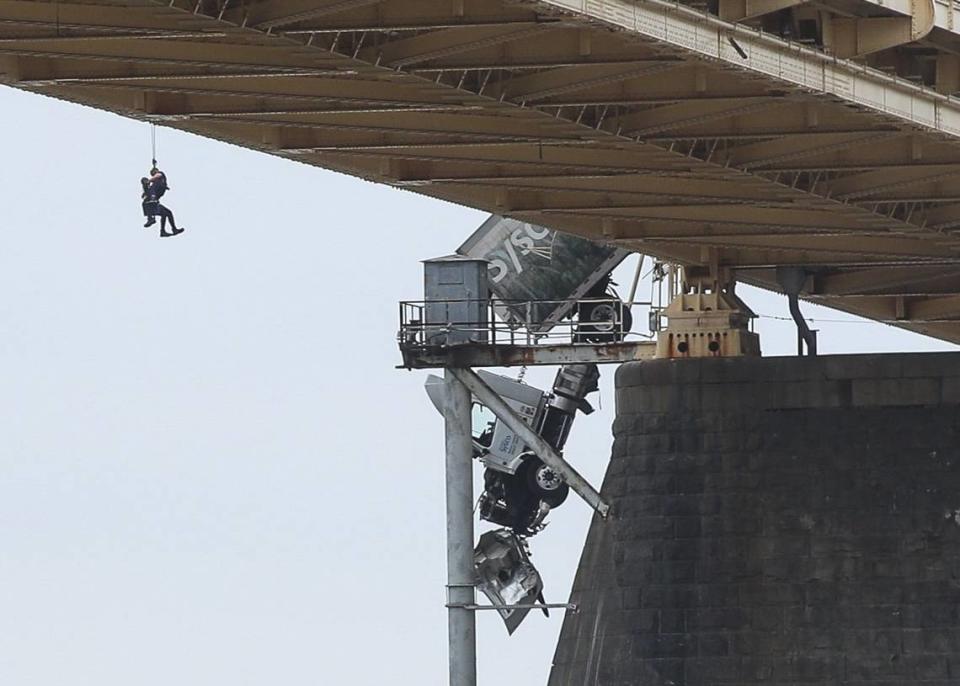 Rescuers work to get a driver out of the cab of a tractor trailer on the Clark Memorial (Second Street) Bridge in Louisville, Ky., March 1.