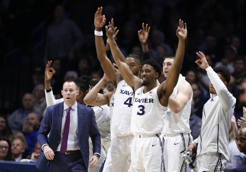 The Xavier bench, including head coach Travis Steele, left, cheer a 3-point basket against St. John's during the second half of an NCAA college basketball game, Sunday, Jan. 5, 2020, in Cincinnati. Xavier won 75-67. (AP Photo/Gary Landers)