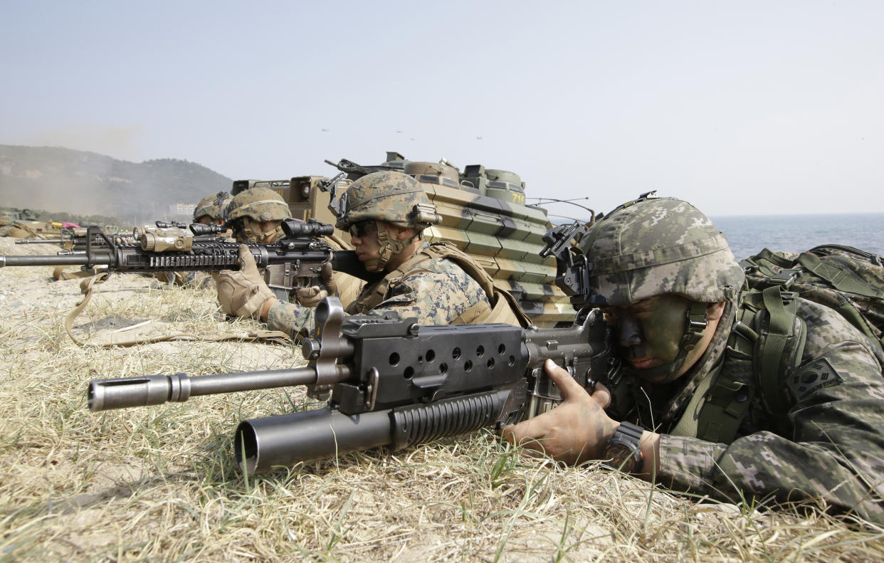 In this 2015 photo, a South Korean Marine, right, and U.S. Marines aim their weapons near amphibious assault vehicles during the U.S.-South Korea joint landing military exercises. (Photo: Lee Jin-man/AP)