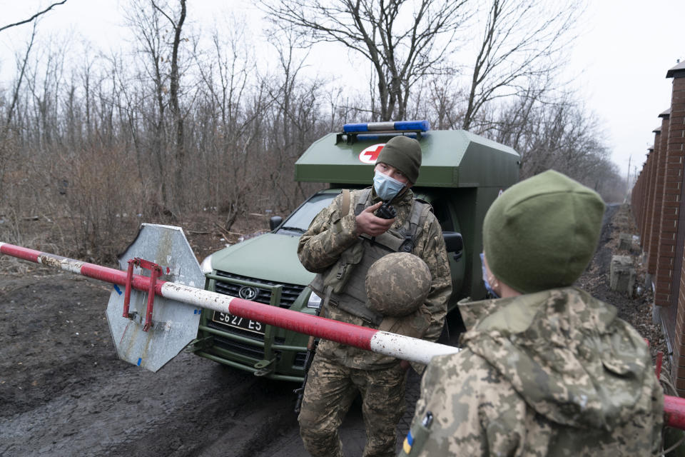 A Ukrainian serviceman speaks on a on the walkie-talkie as military medics arrive at a military base to vaccinate troops near the front-line town of Krasnohorivka, eastern Ukraine, Friday, March 5, 2021. The country designated 14,000 doses of its first vaccine shipment for the military, especially those fighting Russia-backed separatists in the east. But only 1,030 troops have been vaccinated thus far. In the front-line town of Krasnohorivka, soldiers widely refuse to vaccinate. (AP Photo/Evgeniy Maloletka)