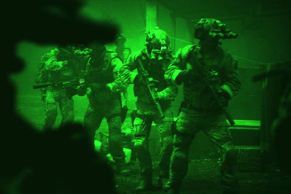 This undated publicity photo released by Columbia Pictures Industries, Inc. shows Navy SEALs seen through the greenish glow of night vision goggles, as they prepare to breach a locked door in Osama Bin Laden's compound in Columbia Pictures' hyper-realistic new action thriller from director Kathryn Bigelow, "Zero Dark Thirty." (AP Photo/Columbia Pictures Industries, Inc., Jonathan Olley)