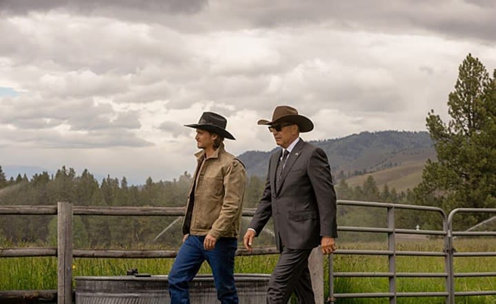 Two men walk on a ranch in Yellowstone.