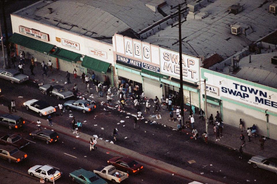 In this April 29, 1992 file photo, people enter and leave a swap meet in South Central Los Angeles. Violence broke out in the area after four Los Angeles police officers were acquitted on all but one charge for the videotaped beating of motorist Rodney King. 