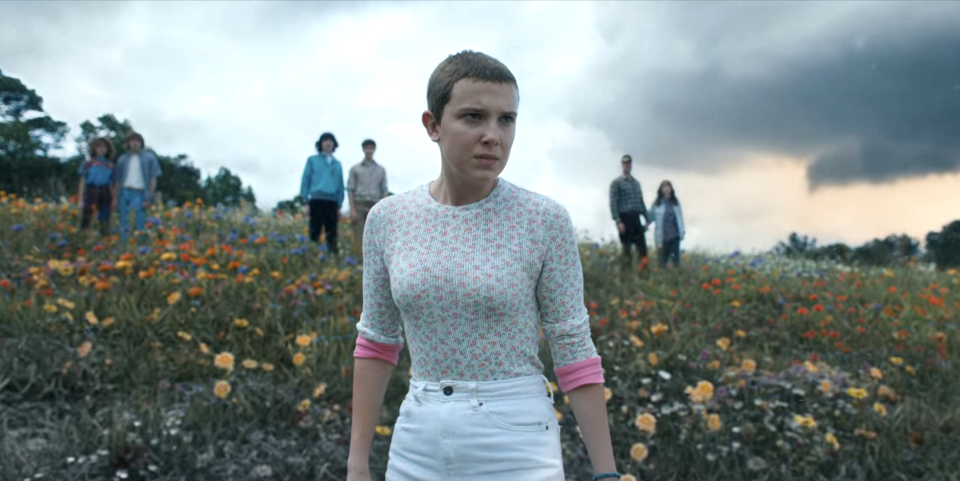 Eleven standing ahead of others in a field of flowers