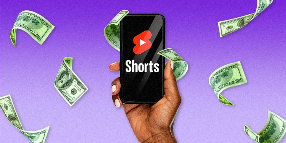Hand holding phone with YouTube shorts logo and money flying around 2x1