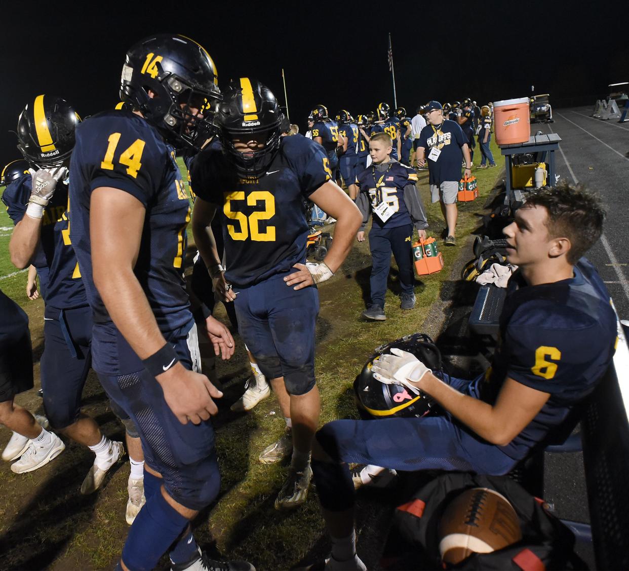 Cooper Nye, Isaac Kemp and Colin Nowak of Airport talk after another touchdown pass from Nye to Nowak against Detroit East English during a 70-18 Airport rout in a Division 4 playoff game on Friday, October 27, 2023.