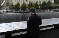 New York City Police Champlain Khalid Laitif stands at the edge of the North Pool during memorial observances on the 13th anniversary of the 911 attacks at the site of the World Trade Center in New York, September 11, 2014. REUTERS/Robert Sabo/POOL