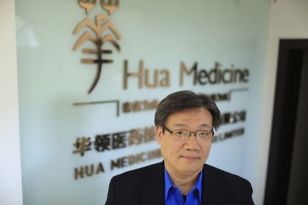 Li Chen, co-founder and CEO of Hua Medicine, poses for a photograph in front of a company logo, at his office in Shanghai, February 11, 2015. REUTERS/Aly Song